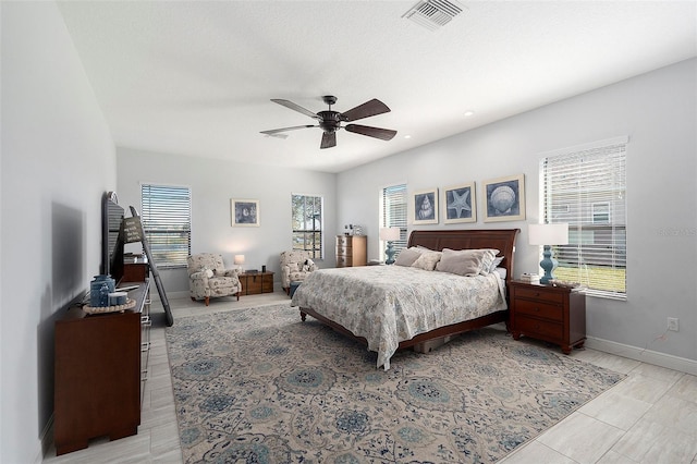 bedroom with multiple windows and ceiling fan