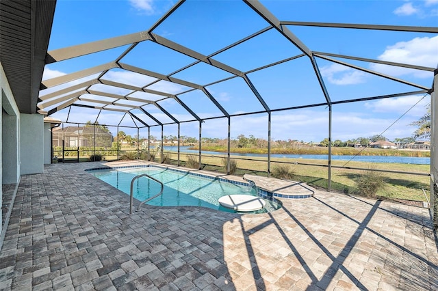 view of swimming pool with a patio, a water view, and glass enclosure