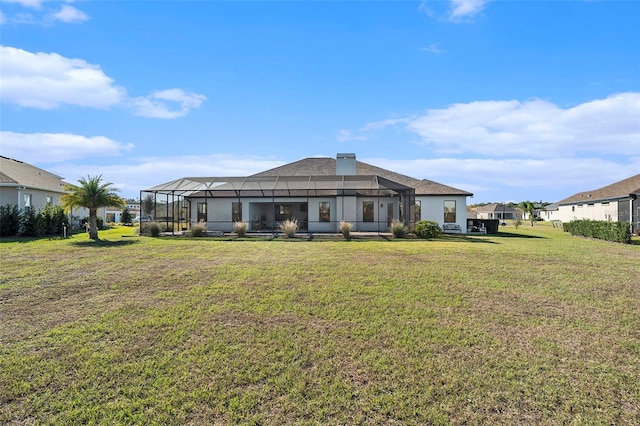 rear view of house featuring a lawn and glass enclosure