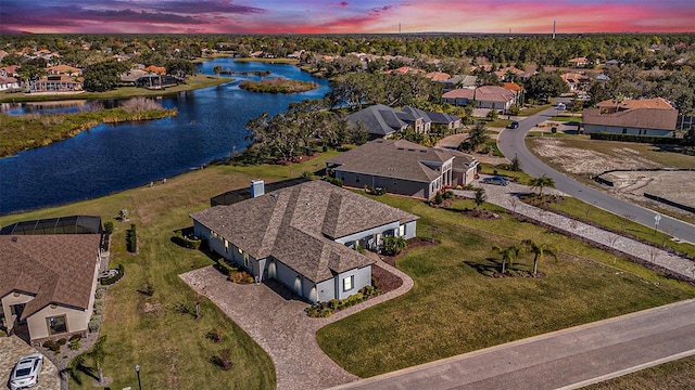 aerial view at dusk featuring a water view