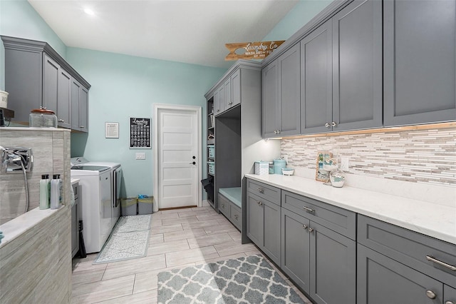 laundry area featuring washer and clothes dryer and cabinets