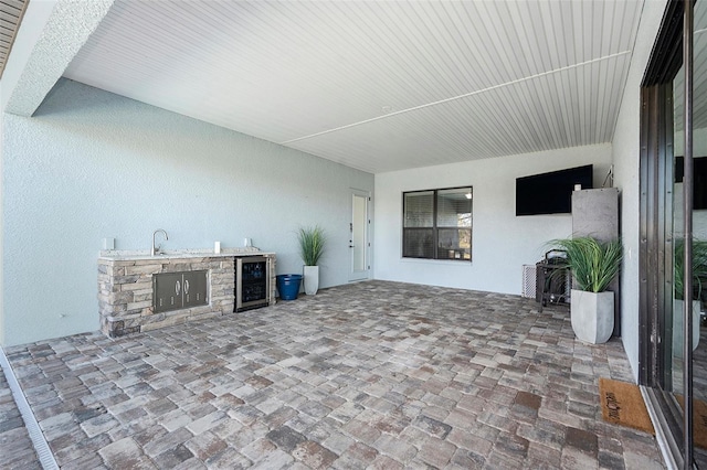 view of patio featuring sink, beverage cooler, and exterior kitchen