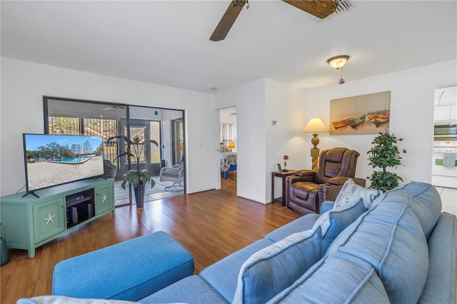 living room featuring a healthy amount of sunlight, dark wood-type flooring, and a textured ceiling