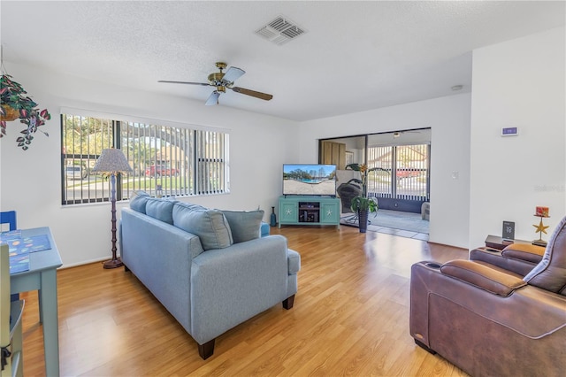 living room featuring a textured ceiling, ceiling fan, a healthy amount of sunlight, and hardwood / wood-style floors