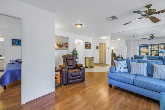 living room with a textured ceiling and light hardwood / wood-style flooring