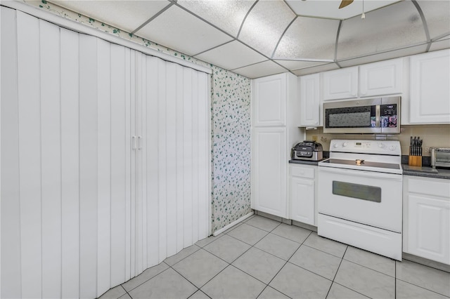 kitchen featuring white cabinetry, ceiling fan, white electric range oven, light tile patterned flooring, and a drop ceiling