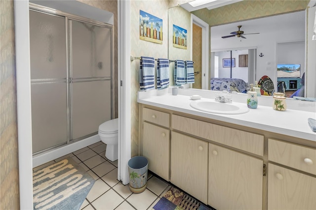 bathroom featuring toilet, a shower with shower door, ceiling fan, tile patterned floors, and vanity