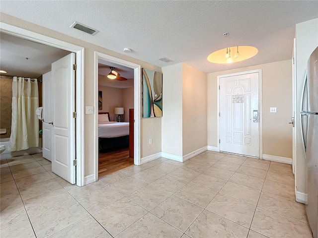 tiled foyer featuring a textured ceiling