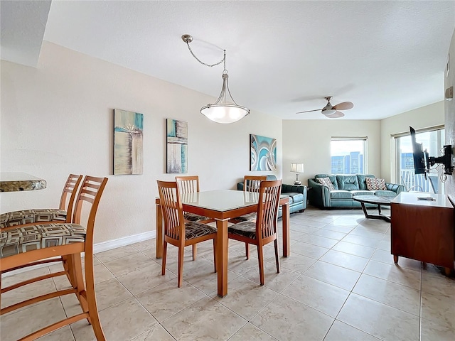 dining space featuring ceiling fan and light tile patterned flooring