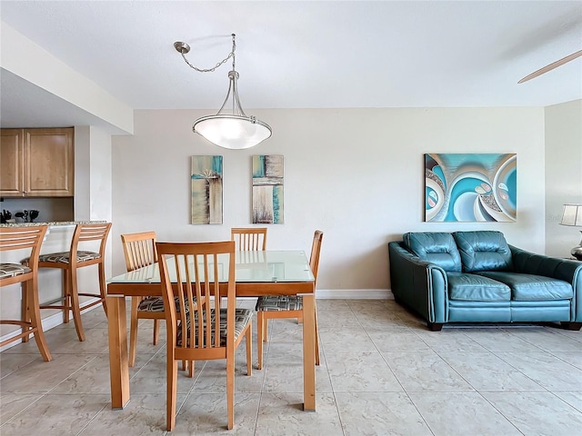 tiled dining space featuring ceiling fan