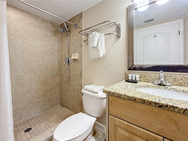 bathroom featuring a shower with curtain, vanity, a textured ceiling, and toilet