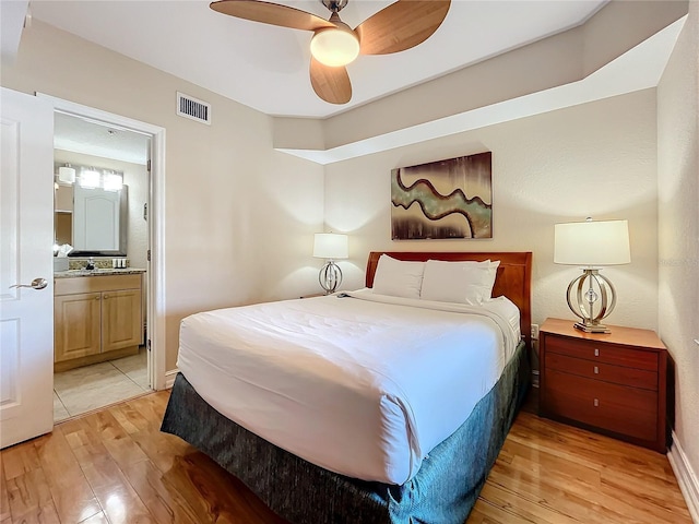 bedroom featuring ensuite bathroom, ceiling fan, and light hardwood / wood-style floors