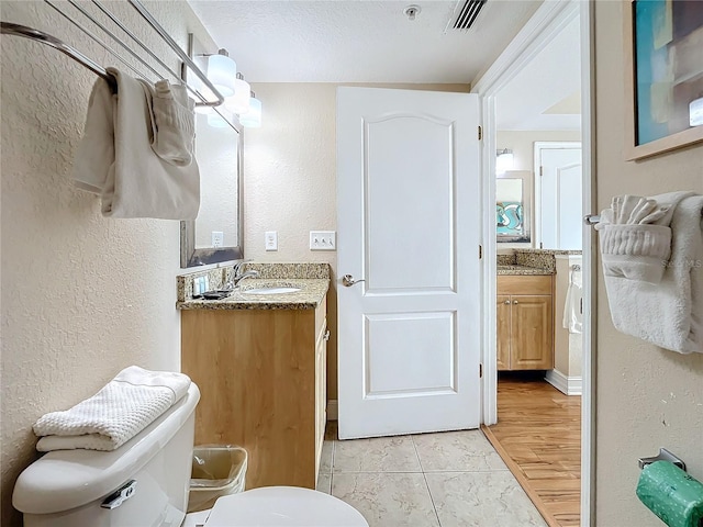 bathroom with hardwood / wood-style flooring, vanity, and toilet