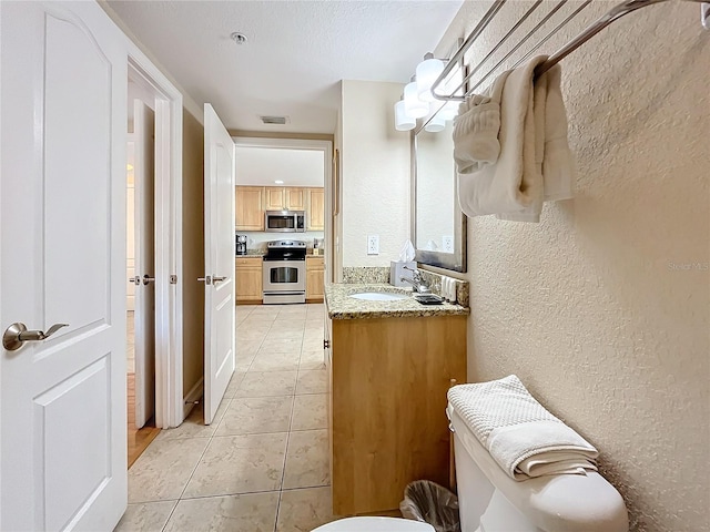 bathroom with tile patterned flooring, vanity, and toilet