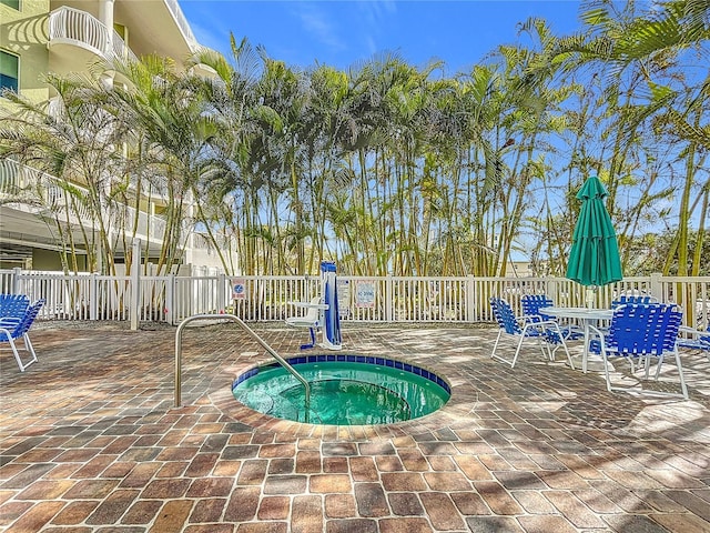 view of swimming pool featuring a community hot tub and a patio