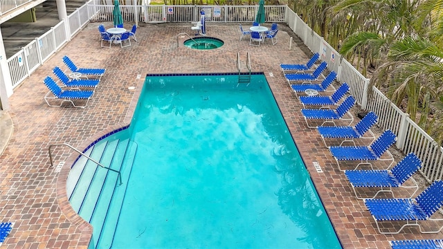 view of swimming pool with a patio and a hot tub