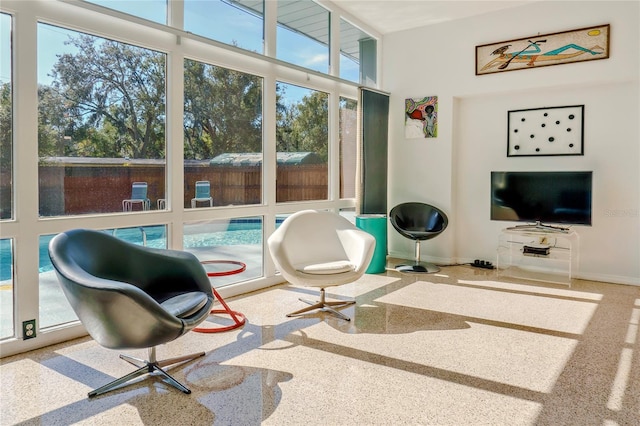 sitting room featuring speckled floor and baseboards