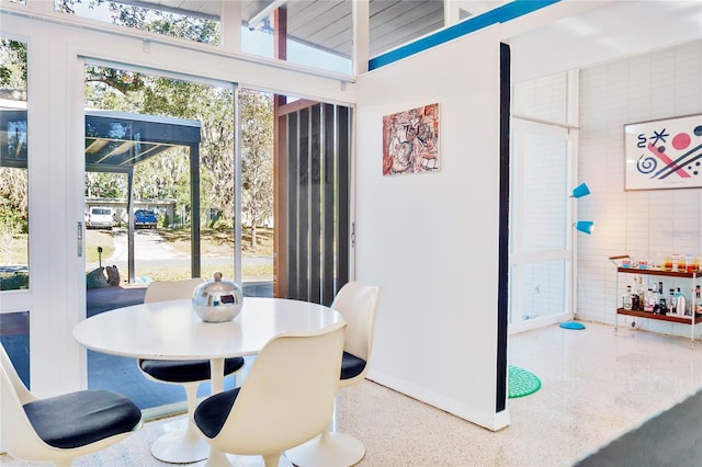 dining area with speckled floor and vaulted ceiling