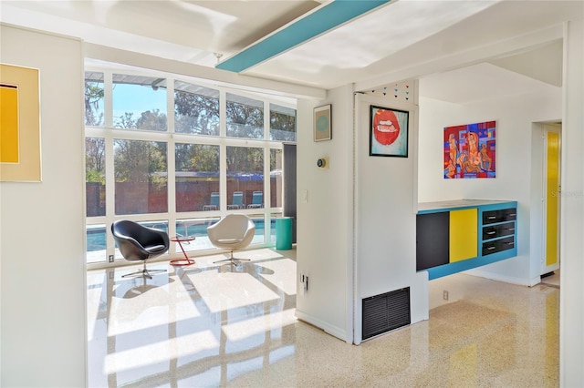 interior space with visible vents, speckled floor, and baseboards