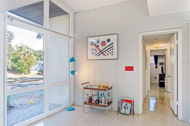 game room with tile walls and speckled floor