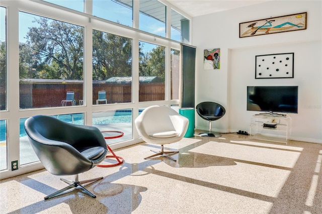 living area with speckled floor and baseboards