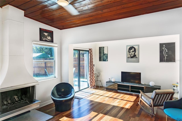 living area with wood ceiling, baseboards, and wood finished floors