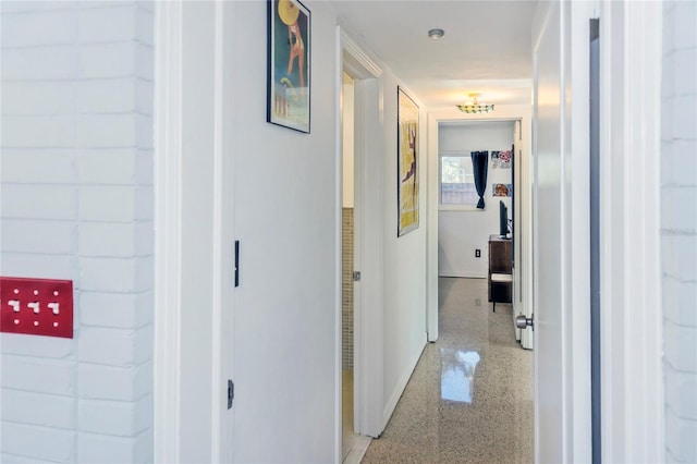 hall with light speckled floor and baseboards