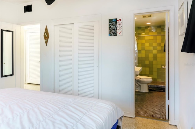 bedroom with ensuite bath, visible vents, and a closet