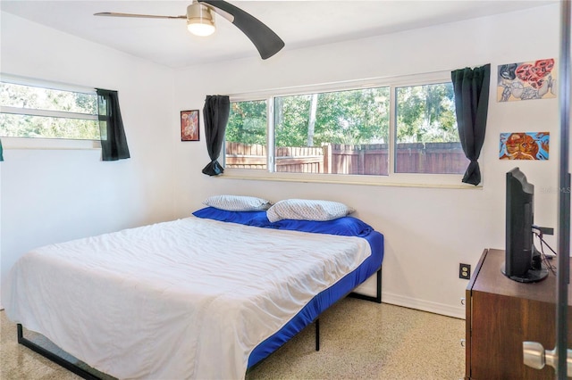 bedroom featuring speckled floor, baseboards, and ceiling fan