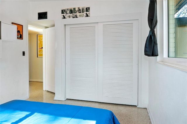 bedroom featuring baseboards, a closet, light speckled floor, and visible vents