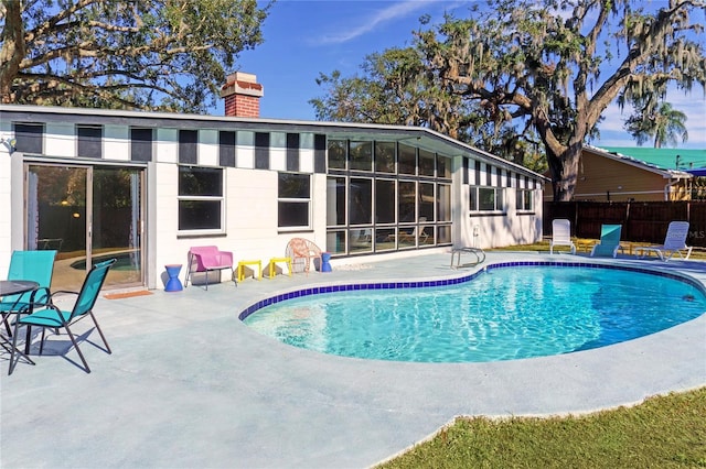 view of swimming pool featuring a patio, fence, and a fenced in pool