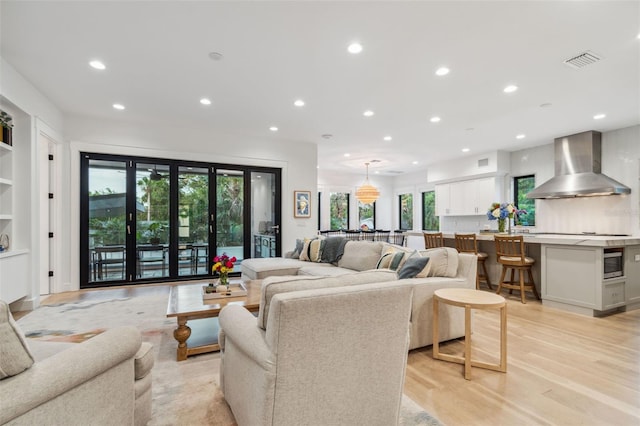 living room with a wealth of natural light and light hardwood / wood-style flooring