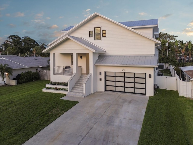 view of front of property featuring a front lawn, covered porch, and a garage