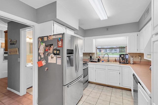 kitchen featuring light tile patterned floors, sink, white cabinetry, and appliances with stainless steel finishes