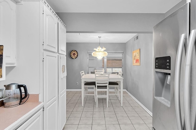 tiled dining room featuring an inviting chandelier