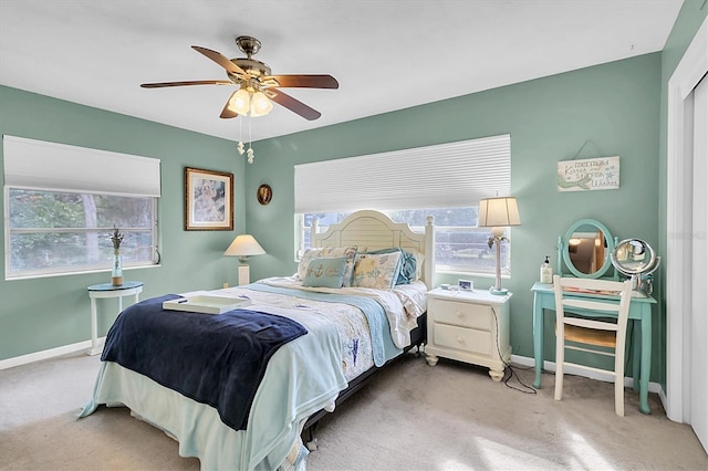 bedroom with ceiling fan, carpet floors, and multiple windows