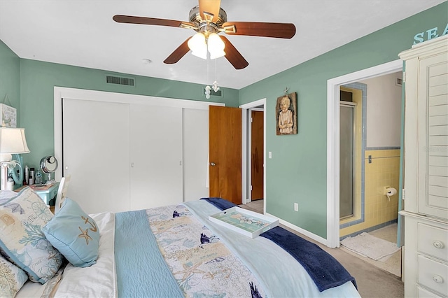 bedroom with ceiling fan, light colored carpet, and a closet