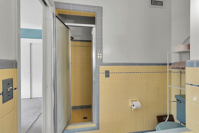 bathroom featuring an enclosed shower and tile walls