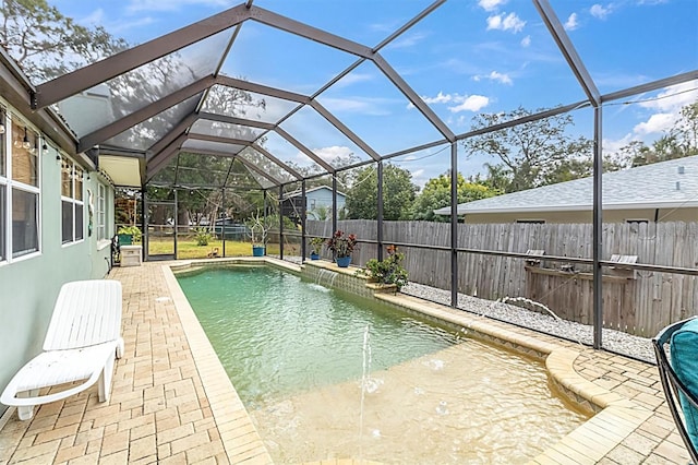 view of swimming pool featuring glass enclosure, a patio area, and pool water feature