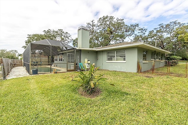 rear view of property featuring a lanai, a swimming pool, and a yard