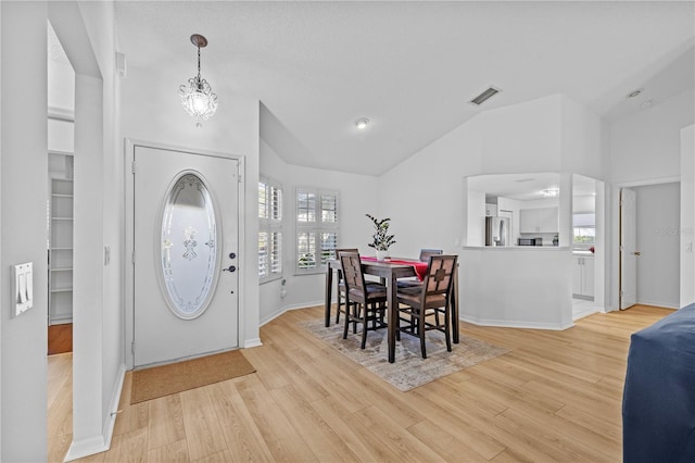 entrance foyer featuring a wealth of natural light, vaulted ceiling, and light wood-type flooring