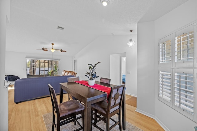 dining space with lofted ceiling, ceiling fan, light hardwood / wood-style floors, and a textured ceiling