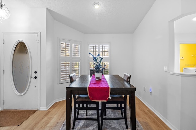 dining area with washer / dryer, a textured ceiling, and light hardwood / wood-style flooring