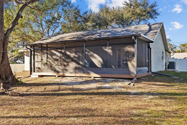 view of side of property featuring cooling unit, a yard, and a sunroom