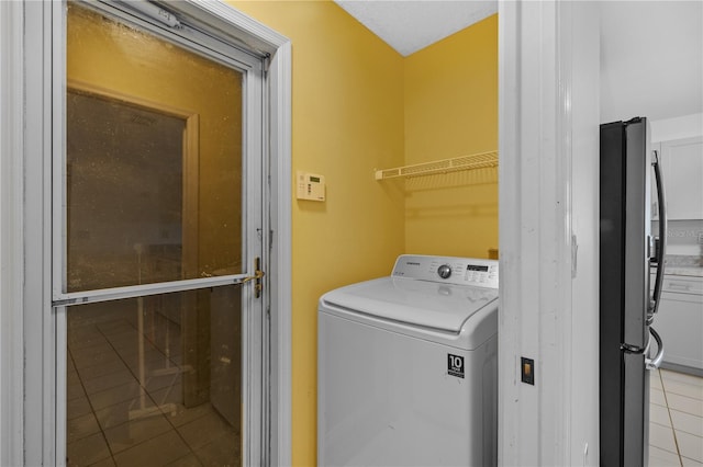 laundry room with light tile patterned flooring and washer / dryer