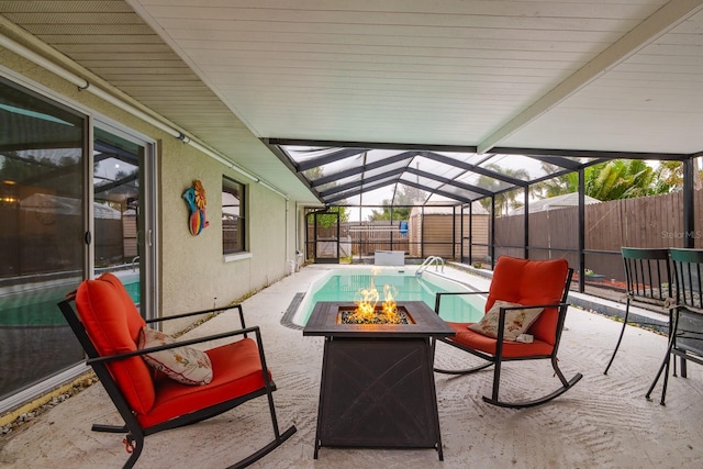 view of patio with a fire pit, a storage shed, and glass enclosure