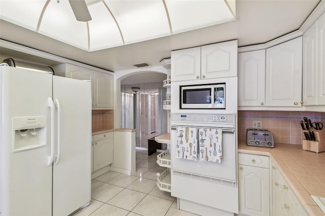 kitchen featuring white cabinetry, white appliances, and tasteful backsplash