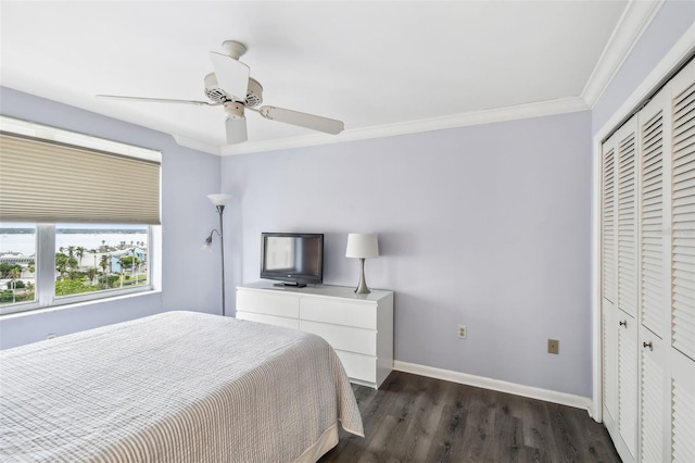 bedroom with ceiling fan, dark wood-type flooring, a closet, and crown molding