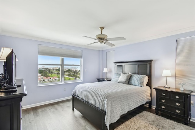 bedroom with ceiling fan, hardwood / wood-style floors, and crown molding