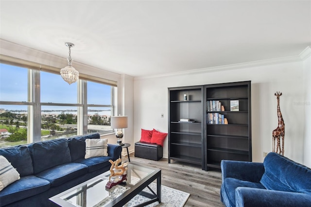 living room featuring hardwood / wood-style flooring, crown molding, and an inviting chandelier